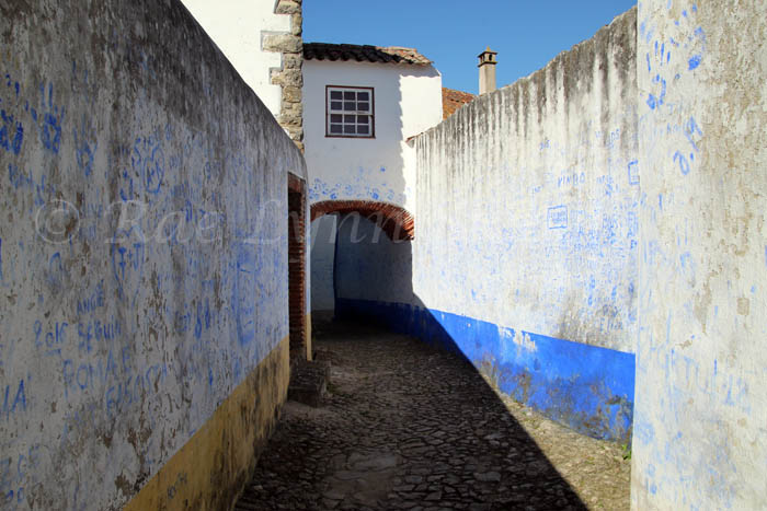dirty while walls with blue handprints in Obidos