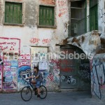 old buildings covered with graffiti as a bicycle rides past
